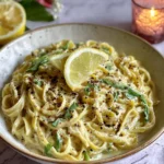 Easy Creamy Lemon Garlic Pasta in a rustic bowl, topped with lemon wedges, cracked pepper, and herbs in a silky cream sauce.