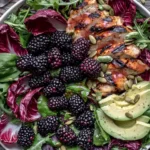 Blackberry Basil Grilled Chicken Salad featuring sliced grilled chicken, fresh blackberries, avocado, basil, arugula, radicchio, and pumpkin seeds with blackberry vinaigrette.