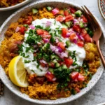 Golden Ground Turkey and Rice Skillet topped with creamy garlic yogurt, fresh cucumber tomato salad, red onion, parsley, and lemon wedges in a rustic serving bowl.