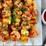 Sweet and Spicy Pineapple Shrimp Skewers with grilled shrimp, caramelized pineapple, sweet chili glaze, fresh parsley, and dipping sauce.