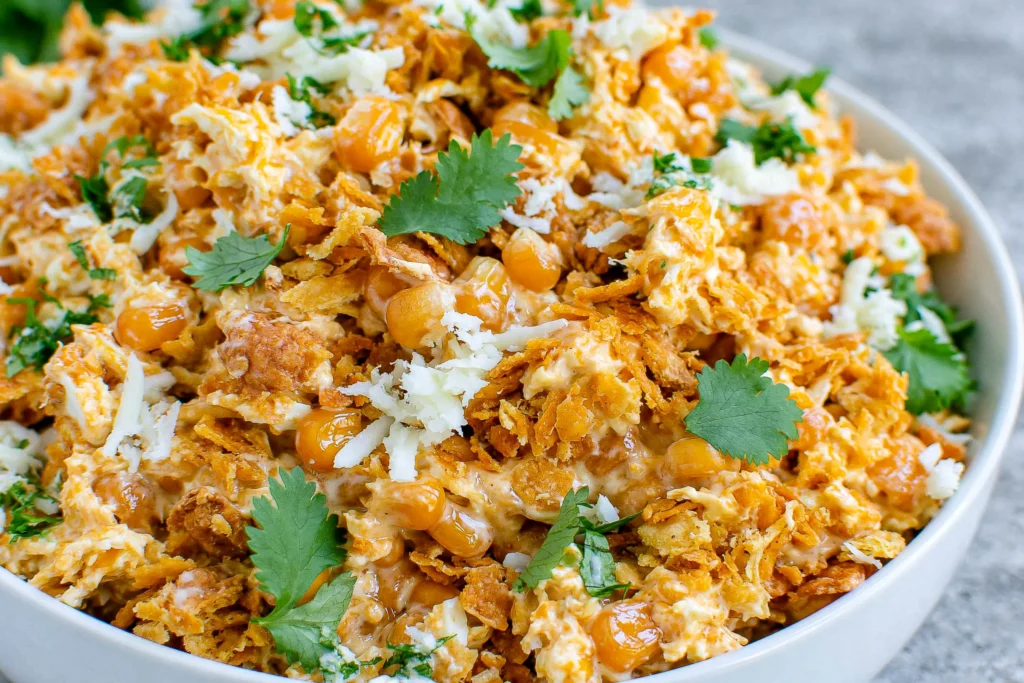 Fritos Corn Salad with Chili Cheese Fritos, sweet corn, shredded Mexican cheese, creamy mayo, and fresh cilantro served in a bowl for an easy party side.