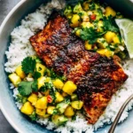 BBQ Salmon Bowls with Mango Avocado Salsa featuring smoky baked salmon over fluffy white rice with fresh mango avocado salsa, cilantro, and a lime wedge.
