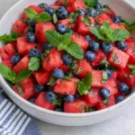 Watermelon Blueberry Salad made with juicy watermelon, fresh blueberries, chopped mint, and honey lime dressing in a serving bowl.