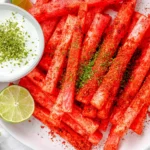 Spicy Watermelon Fries seasoned with chili lime spice, served with a creamy lime yogurt dipping sauce and fresh lime wedges on a white platter.